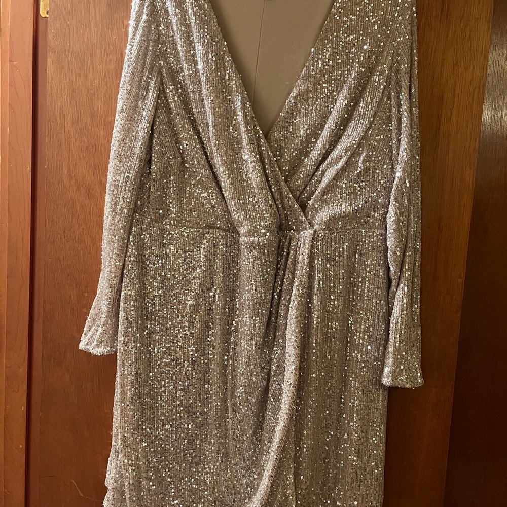 Faux wrapped sequin dress with nude background. Sequins appear to be silvery.
